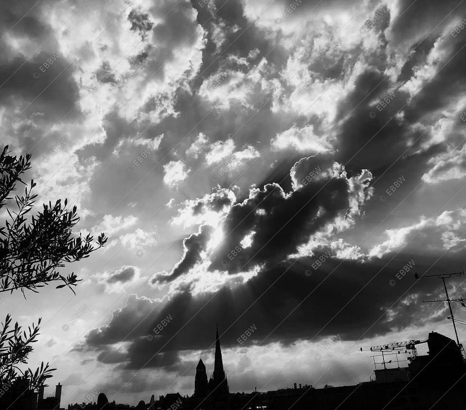 Rayons de soleil à travers les nuages au-dessus d’un clocher